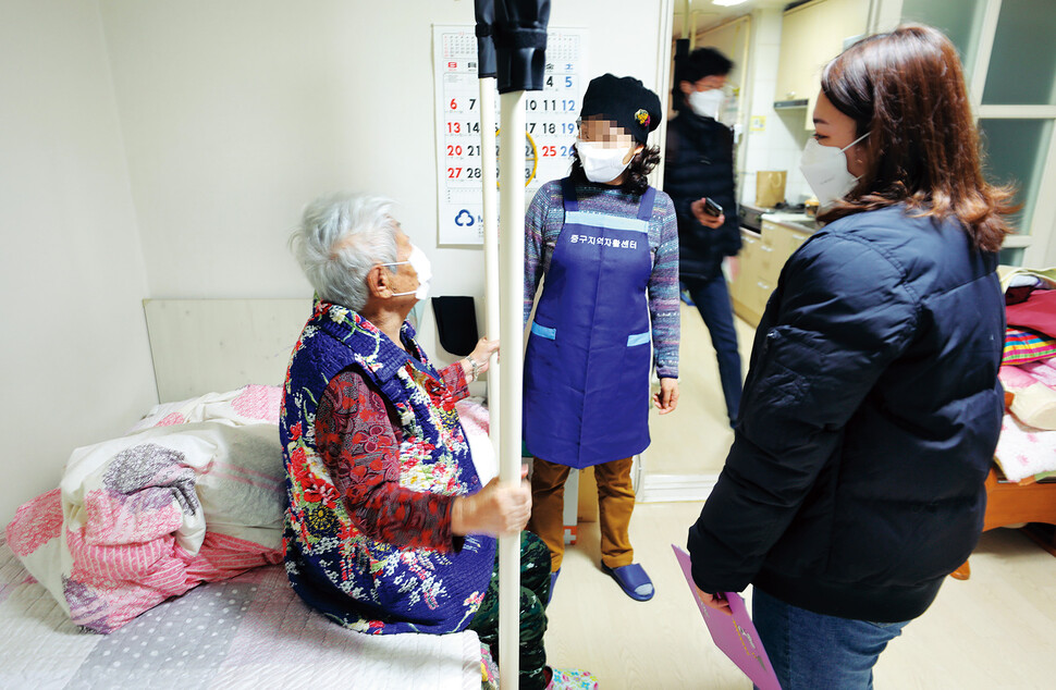 치매를 앓는 할머니(왼쪽)가 자신의 집 안방에서 요양보호사(가운데)와 대화를 나누고 있다. 정용일 선임기자