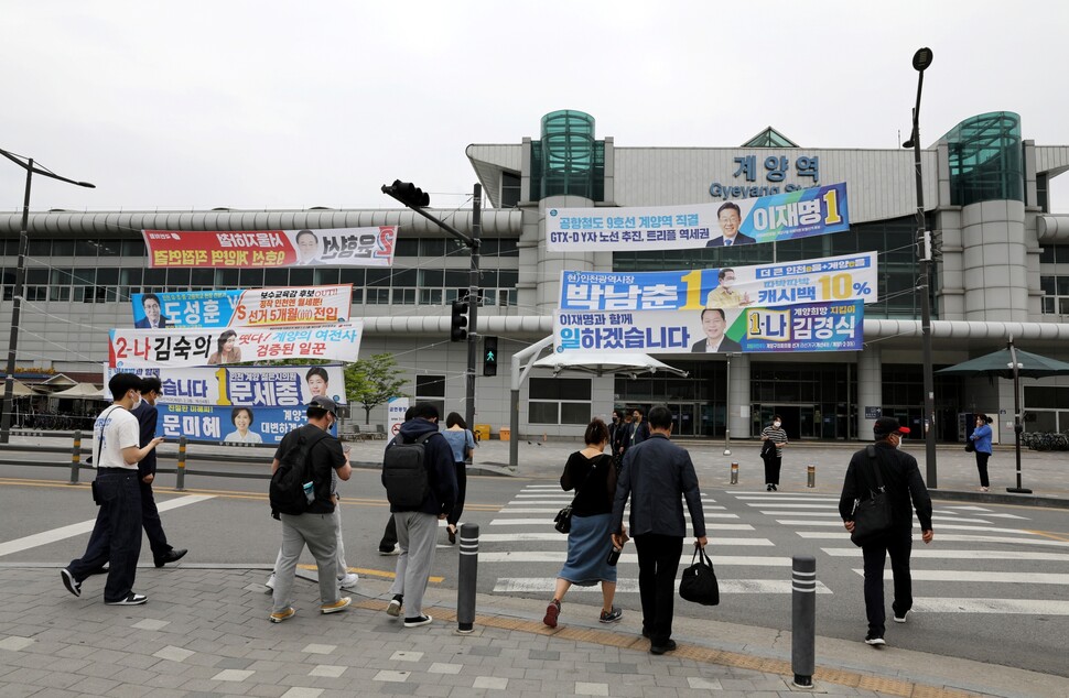 인천 계양구 시민들이 6·1 지방선거를 이틀 앞둔 2022년 5월30일 펼침막이 즐비한 인천 계양역으로 걸어가고 있다. 류우종 기자