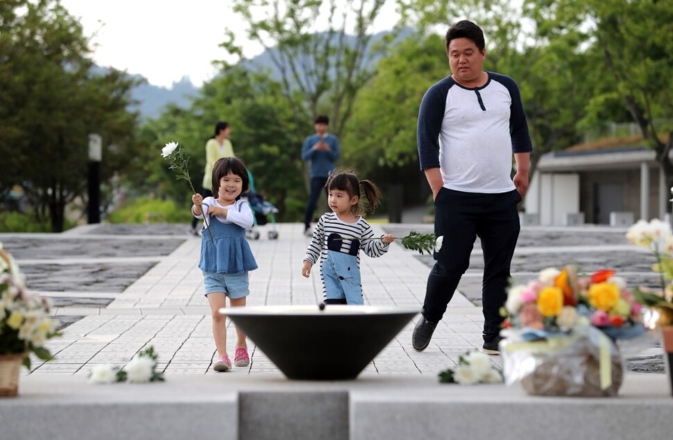 노무현 전 대통령 묘역 앞 분향소에 꽃을 놓기 위해 어린이가 걸어오고 있다.