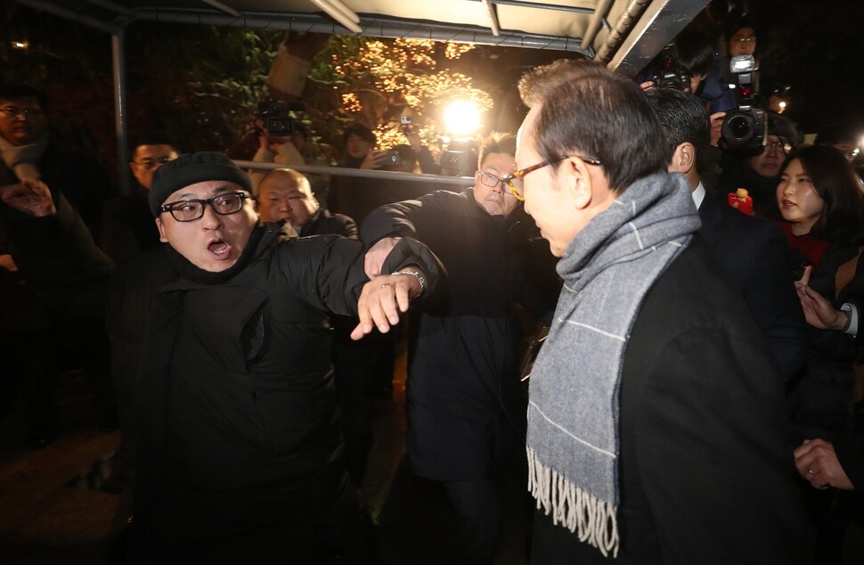 Former President Lee Myung-bak is approached by a protester upon entering a restaurant in the Gangnam district of Seoul for a year-end party on Dec. 18. (by Shin So-young