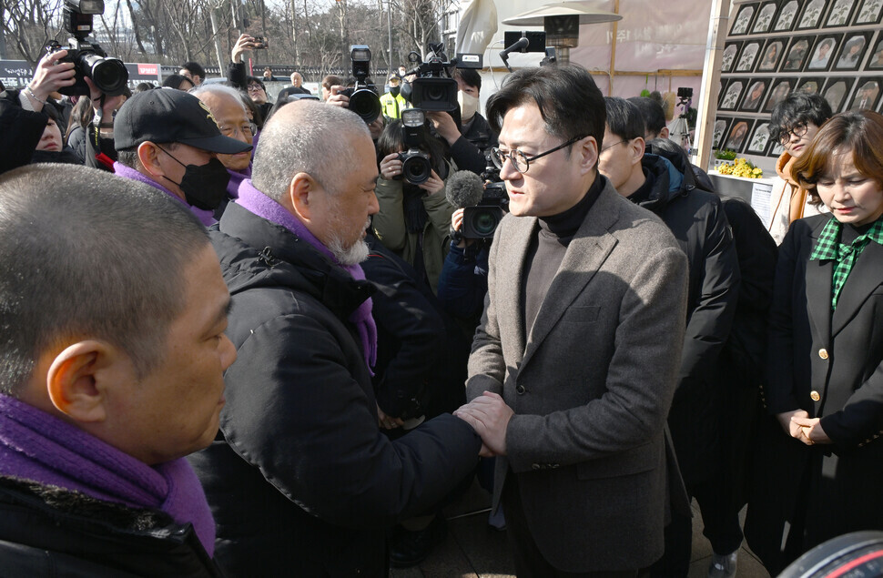 Hong Ihk-pyo, the floor leader of the opposition Democratic Party, greets families of those killed in the 2022 Itaewon crowd crush during his visit to a joint memorial altar in Seoul Plaza on the afternoon of Jan. 30. (pool photo)