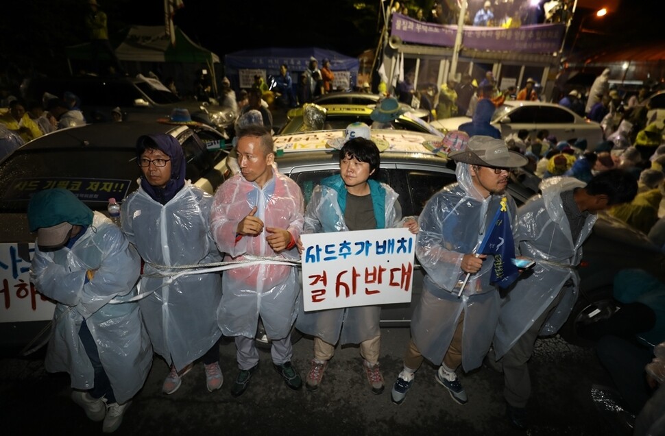 시민들이 밧줄로 서로의 몸을 묶고 사드 발사대 수송차 진입을 막고 있다.