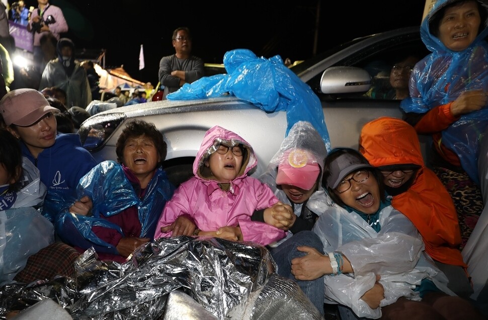 경북 성주군 초전면 소성리 마을회관 앞에서 사드 발사대 수송 행렬을 저지하기 위해 도로를 점거한 집회 참가자들이 경찰 병력이 다가오자 끌려가지 않으려고 서로 팔짱을 끼고 있다.