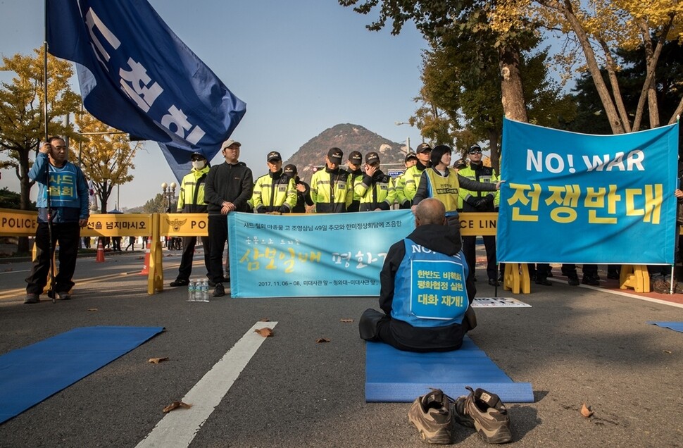 삼보일배가 경찰에 가로막히자 명상을 하는 문규현 신부.