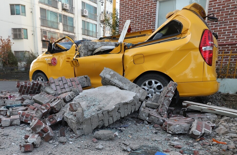 한 어린이집 차량이 무너진 벽돌 더미에 깔려 심하게 찌그러졌다.