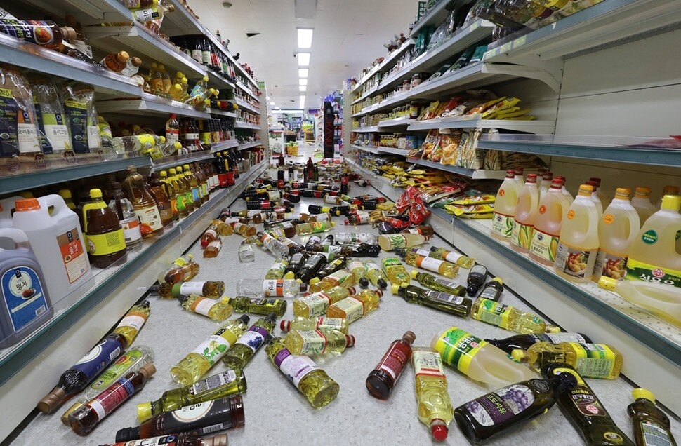 한 마트에서 지진으로 선반에서 떨어진 물건들이 바닥에 흩어져 있다.