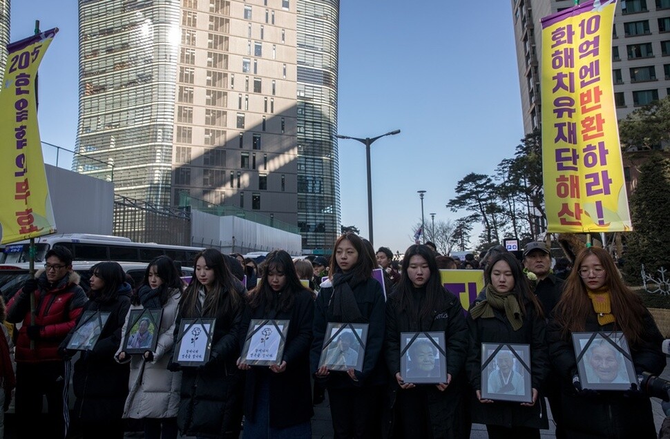 수요집회를 마친 참가자들이 할머니들의 영정을 들고 행진하고 있다.