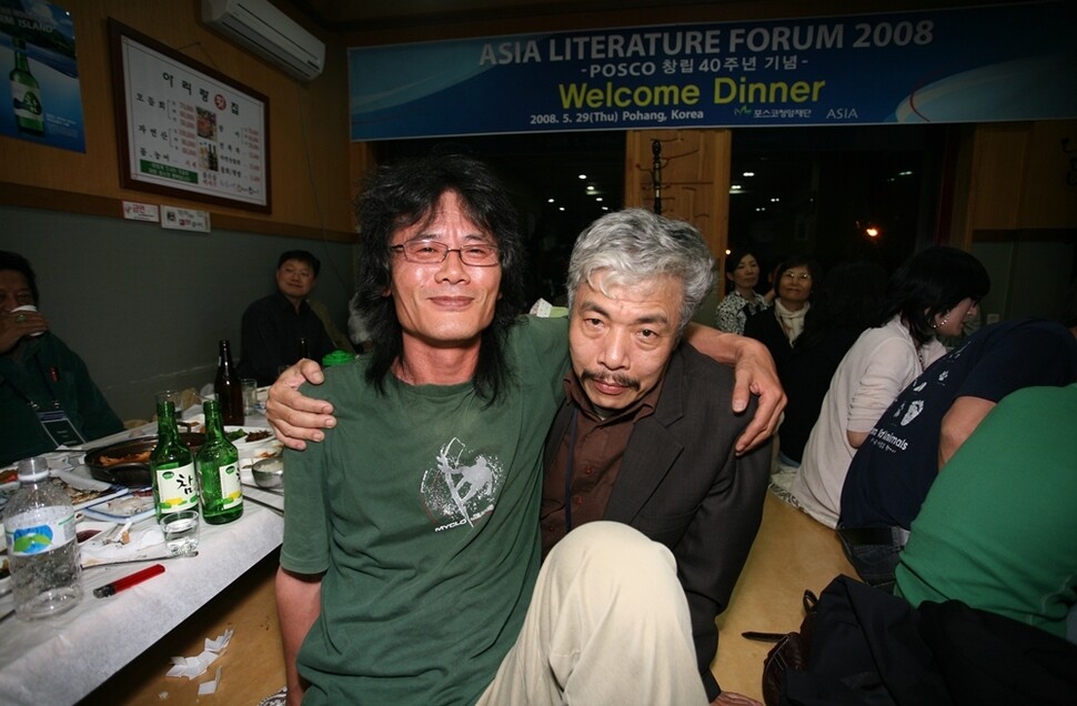 2008년 포스코가 주최한 아시아문학포럼에 초청된 바오 닌 작가(오른쪽)와 김남일 작가가 경북 포항의 한 식당에서 사진을 찍었다. 뒤 왼쪽에 방민호 서울대 교수, 오른쪽에 소설가 이경자, 함정임이 살짝 보인다. 사진가 최경자 제공