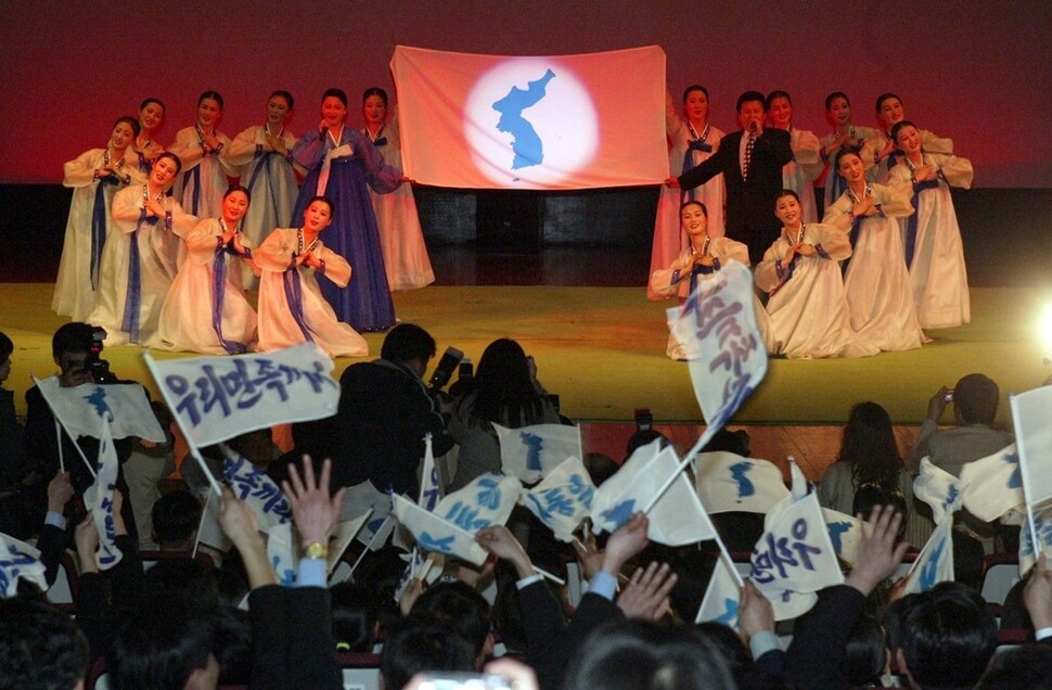 2004년 3월13일 금강산에서 열린 ‘남북금강산새내기배움터’에 참가한 남북 대학생들이 한반도기를 흔들며 북쪽 공연을 관람하고 있다. 금강산/ 연합뉴스