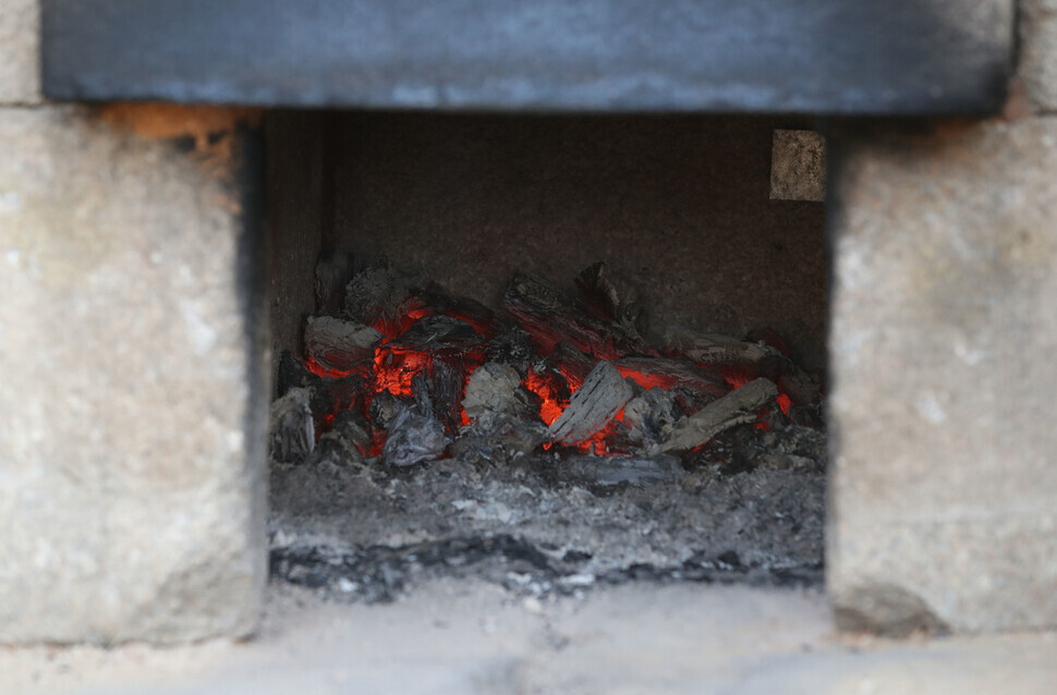 Embers glow in the agungi fire pit at Hyangwonjeong Pavilion. (Kim Hye-yun/The Hankyoreh)