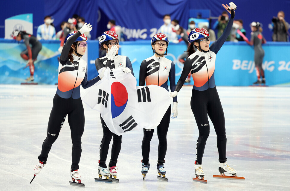 Athletes on South Korea’s women’s short track speedskating team wave to the crowd as they hold the national flag after winning silver in the 3,000-meter relay Sunday at the 2022 Beijing Olympics. (Yonhap News)