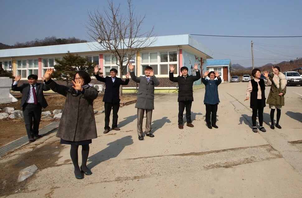 폐교식이 끝나고 마지막 하교를 하는 학생들을 향해 선생님들이 손을 흔들고 있다.