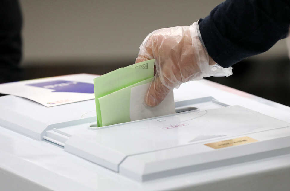 A voter casts a ballot in a polling station set up at an elementary school in Seoul’s Gwangjin District on Apr. 15. (Yonhap News)
