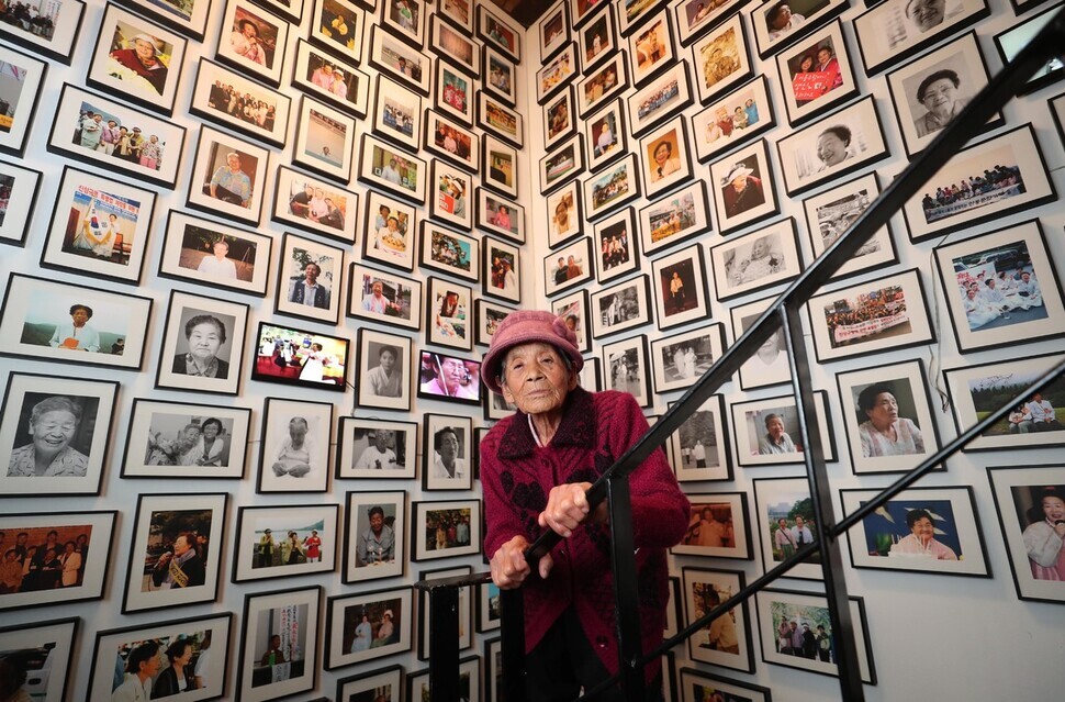 Park Pil-geun stands before a wall of photos of fellow survivors of Japan’s military-sponsored sexual slavery at the Museum of Military Sexual Slavery by Japan in Daegu. (Park Jong-shik/The Hankyoreh)
