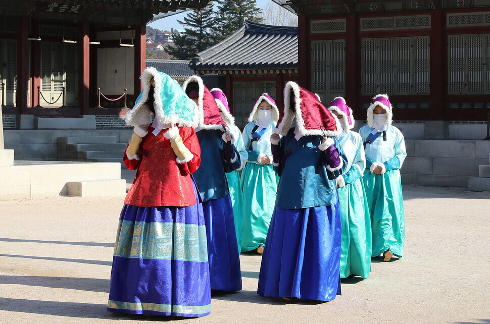 The queen and her attendants walk to Gangnyeongjeon Hall, wearing their winter ieom hats. (Shin So-young/The Hankyoreh)