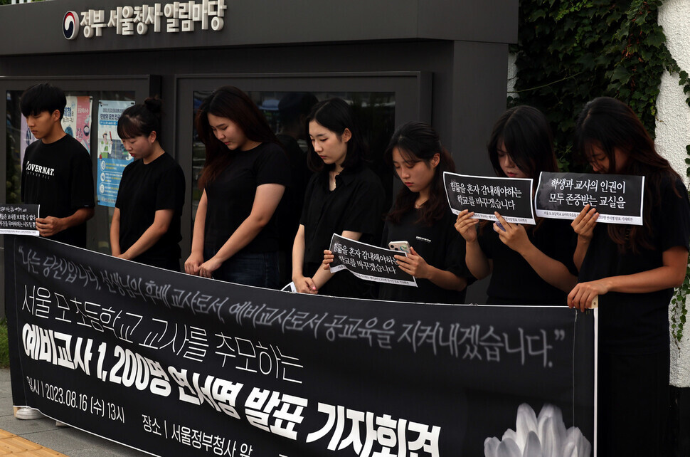 Participants in the press conference hold a moment of silence for the elementary school teacher who was found dead by suicide in her classroom last month. (Yoon Woon-sik/The Hankyoreh)