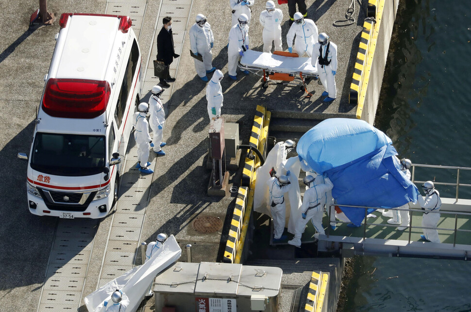 확진자가 대거 나온 일본 크루즈선 다이아몬드 프린세스호에서 방역요원들이 확진자를 이동시키고 있다.  REUTERS