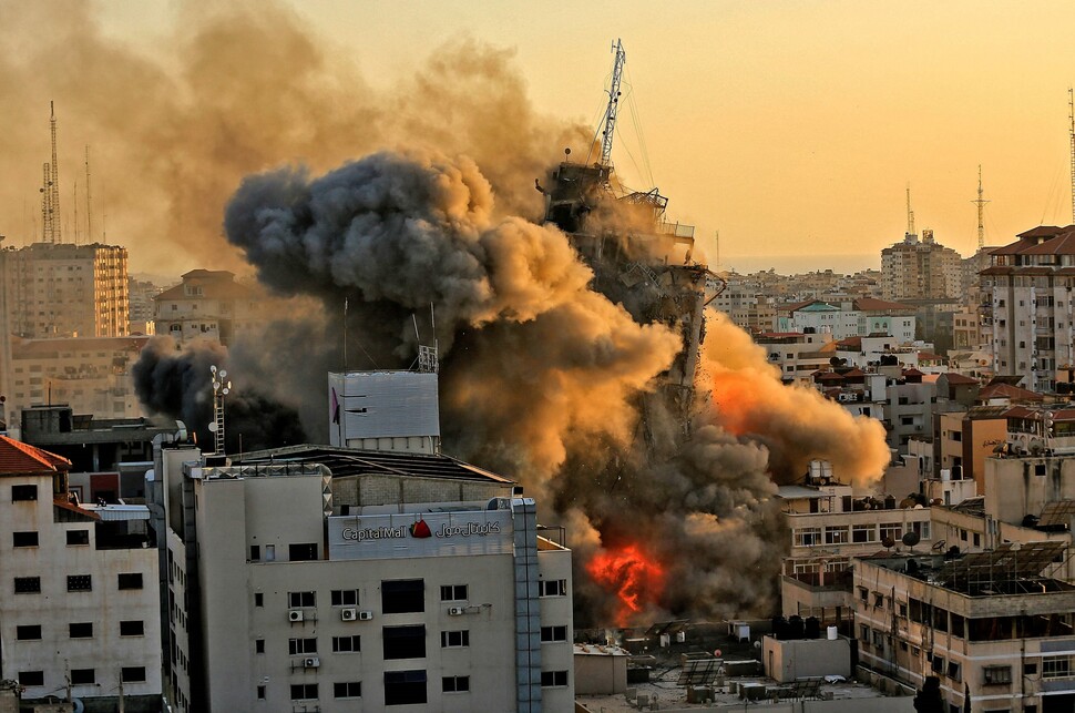 5월12일 이스라엘군의 공습을 받은 팔레스타인 가자시의 알샤루크 타워가 화염에 휩싸인 채 무너져내리고 있다.