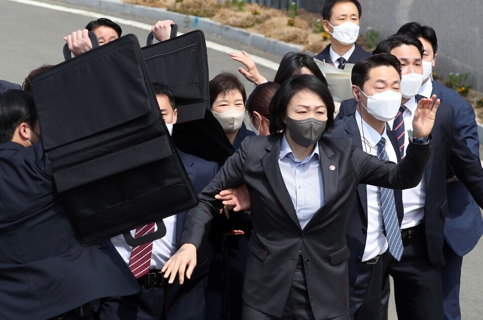 Security guards surround former President Park Geun-hye after a man in the crowd threw a soju bottle while she addressed the public outside her home in Daegu’s Dalseong County on March 24. (Yonhap News)