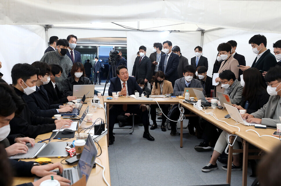 President-elect Yoon Suk-yeol answers questions during a visit to a press tent in front of his transition committee’s office in the Tongui neighborhood of Seoul’s Jongno District on Thursday morning. (pool photo)