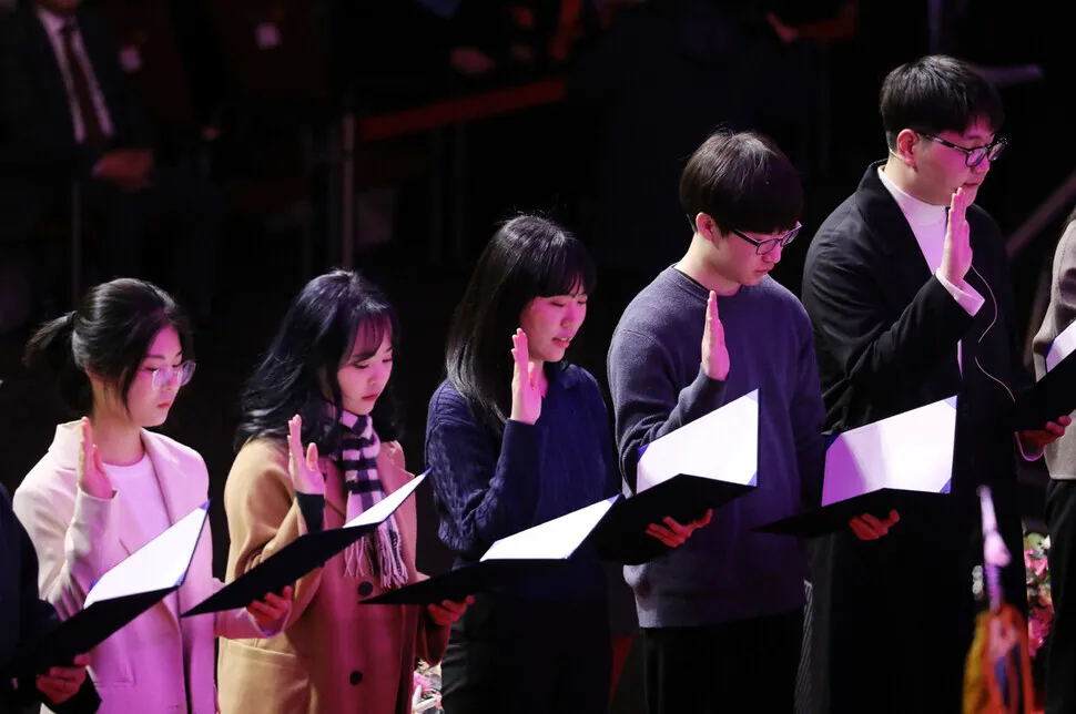 Incoming freshmen at Dongguk University take the stage, unmasked, to make a pledge at a welcome ceremony held at Jangchung Arena, in downtown Seoul, on Feb. 21. (Kim Hye-yun/The Hankyoreh)