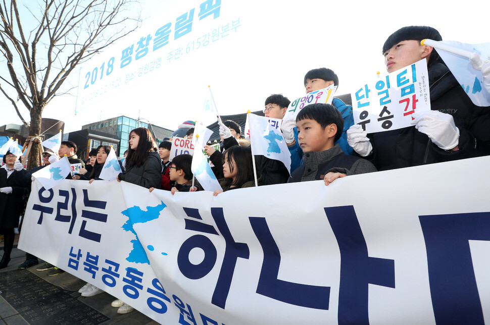 Participants of the inter-Korean cheering team hold a banner that says