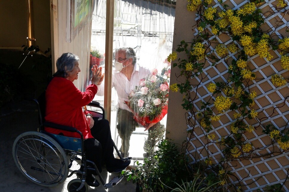 칠레 비나델마르에서 로베르토 루이스(오른쪽)가 은퇴자 거주지에 사는 어머니 엘레나 필리피(80)를 찾아가 창을 사이에 두고 이야기하고 있다.