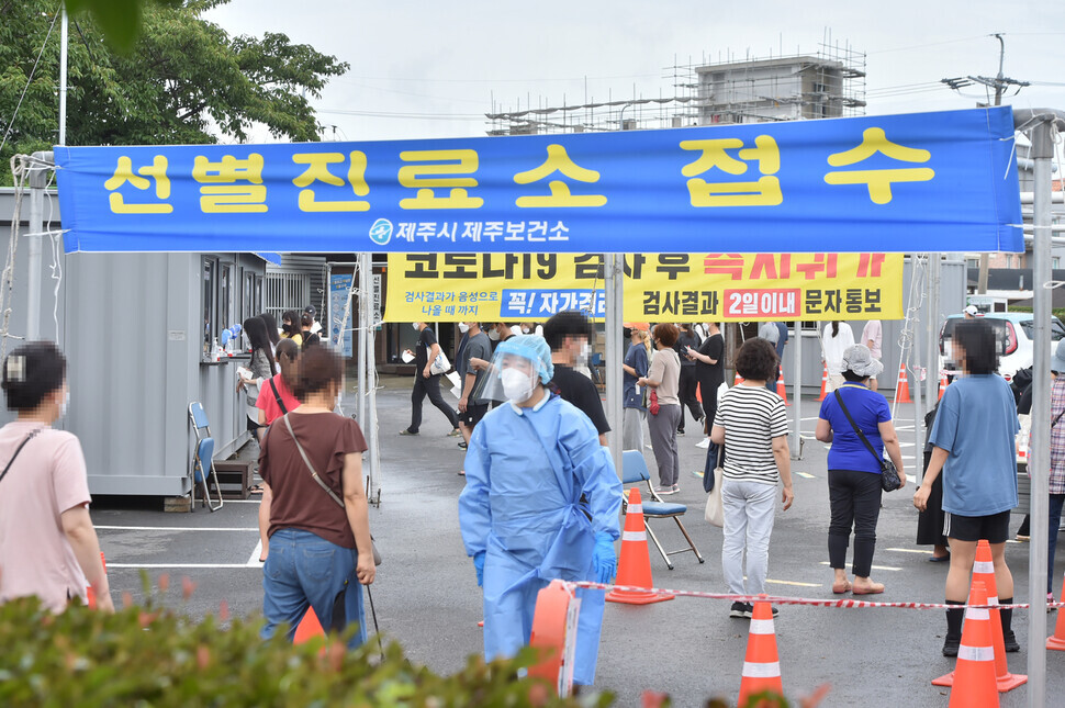 People wait in line to get tested for COVID-19 at a temporary screening center in Jeju that suffered wind damage as Typhoon Omais approached South Korea on Monday. (Yonhap News)