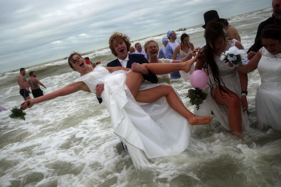 벨기에 오스텐더에서 1월4일 결혼 예복을 차려입은 남녀가 북해에 뛰어들고 있다.