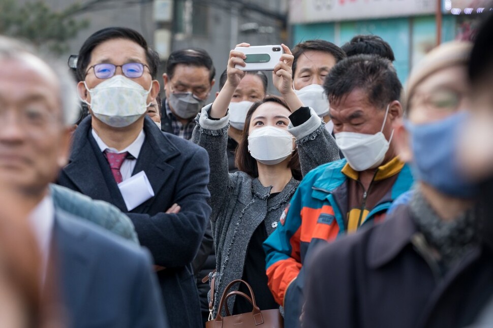 마스크 쓴 시민들이 4월7일 서울 종로구 숭인동 동묘역 주변에서 이낙연 더불어민주당 후보의 유세를 지켜보고 있다.
