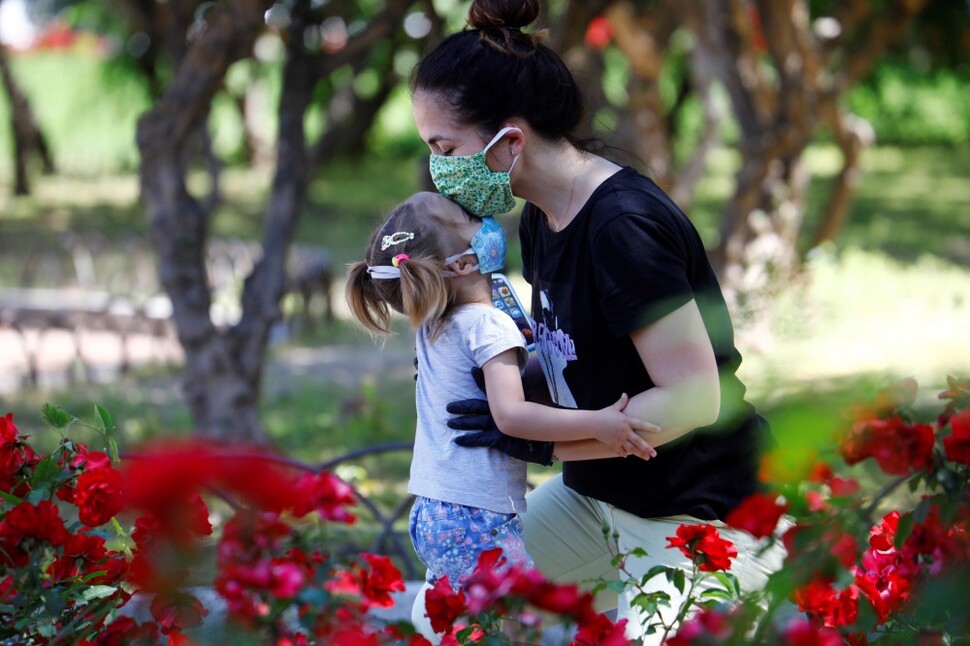 한 어머니가 5월3일 스페인 남부 코르도바의 한 공원에서 마스크를 쓴 채 딸의 이마에 입 맞추고 있다.