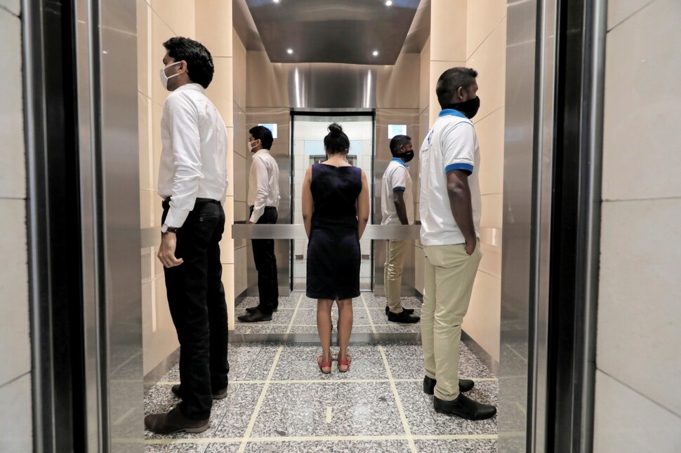 5월11일 스리랑카 콜롬보의 세계무역센터 건물에서 승강기에 오른 사람들이 각자 다른 곳을 보고 있다.