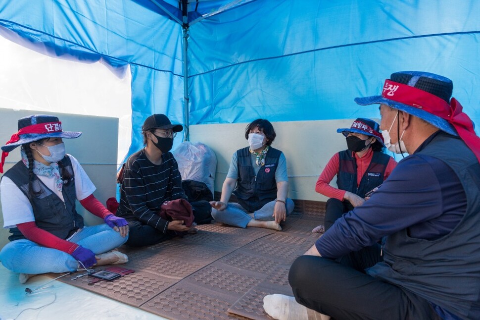 아시아나케이오 해고노동자들이 농성천막을 지지 방문한 시민(왼쪽 둘째)과 이야기하고 있다.