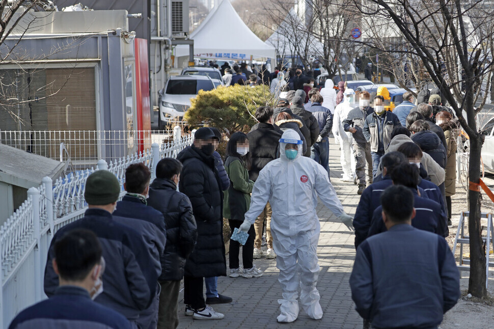 Workers wait in line to get tested for COVID-19 at a temporary screening station in the Jingwan General Industrial Complex on Feb. 17. (Kim Hye-yun)