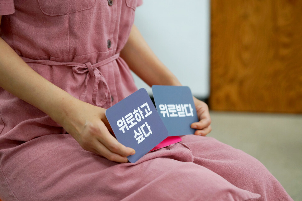 ‘다른몸들’ 워크숍에 참여한 한 여성이 “위로하고 싶다”와 “위로받다”라는 말이 적힌 카드를 내보이고 있다. 혜영 촬영. 다른몸들 제공