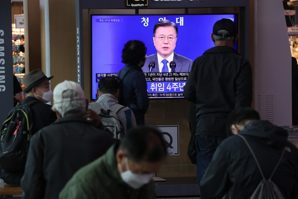 People gather around a television in Seoul Station to watch South Korean President Moon Jae-in deliver an address marking his fourth year in office on Monday. (Kim Bong-gyu/The Hankyoreh)