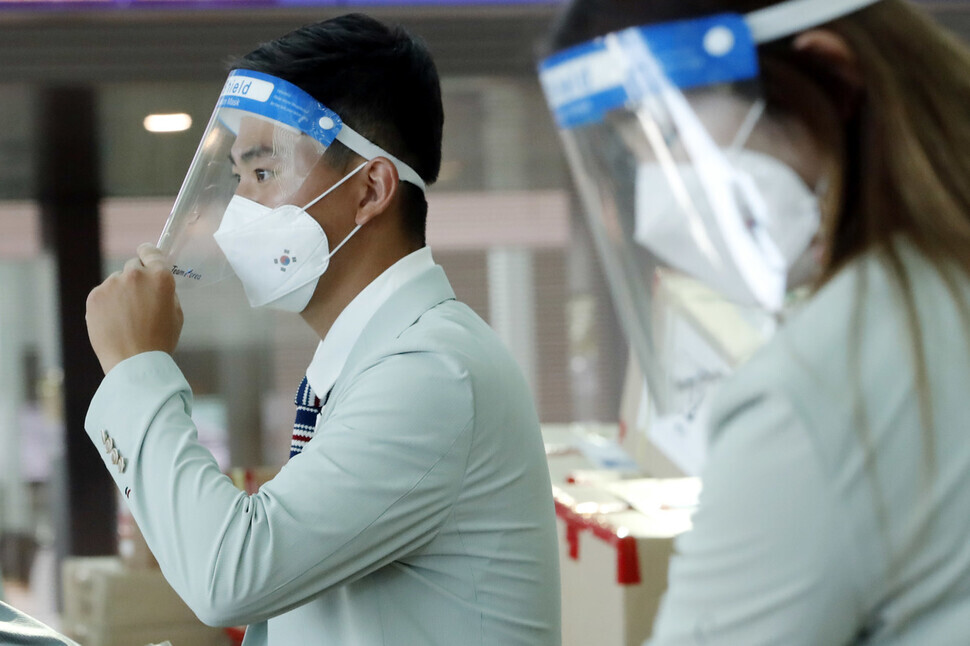 Team Korea archer Kim Je-deok puts on a protective mask as he leaves for Japan on Monday at Incheon International Airport. (Lee Jeong-a/The Hankyoreh)