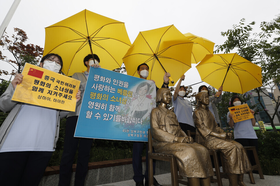 Seongbuk Mayor Lee Seung-roh and students from Gyesung High school hold a rally calling for the permanent preservation of a comfort woman statue in Berlin’s Mitte borough while standing behind comfort woman statues at the entrance of Hansung University Station in Seoul on Wednesday. (Lee Jeong-a/The Hankyoreh)