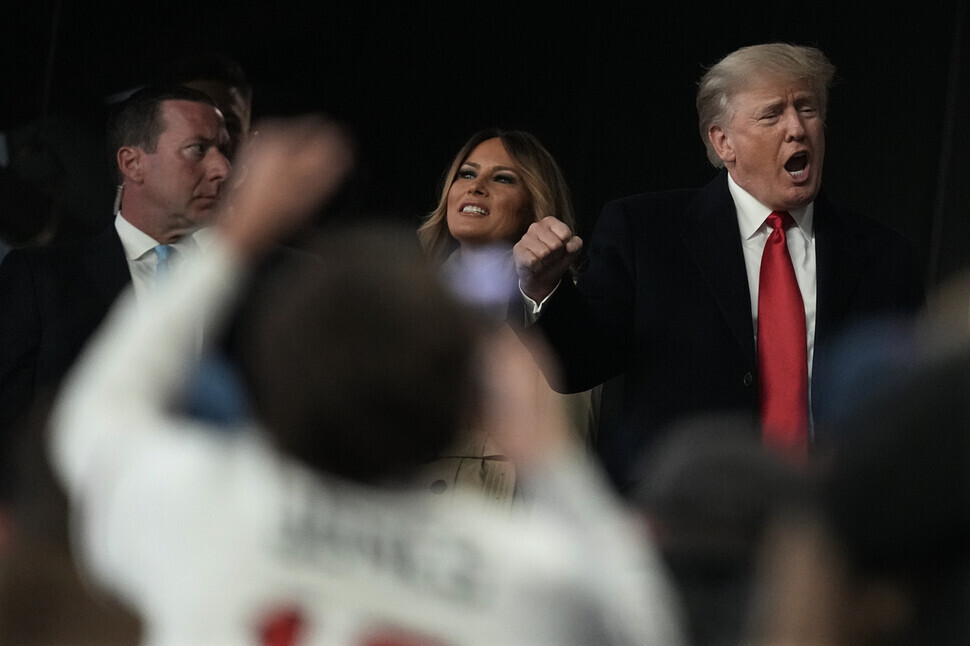 Former US President Donald Trump (right) and his wife Melania Trump (center) watch the Game 4 of the baseball World Series between the Houston Astros and the Atlanta Braves on Oct. 30, 2021, in Atlanta. (AP/Yonhap News)
