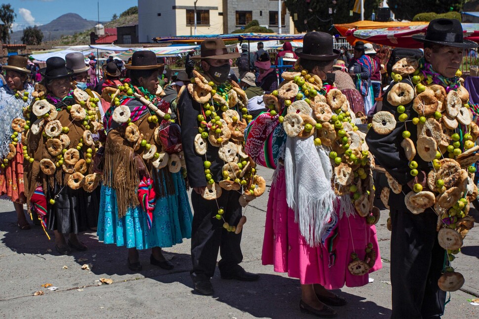 아이마라 원주민들이 페루 남부 푸노 지역의 포마타 거리에서 새해 풍요를 기원하기 위해 빵과 과일을 몸에 두른 채 행진하고 있다.