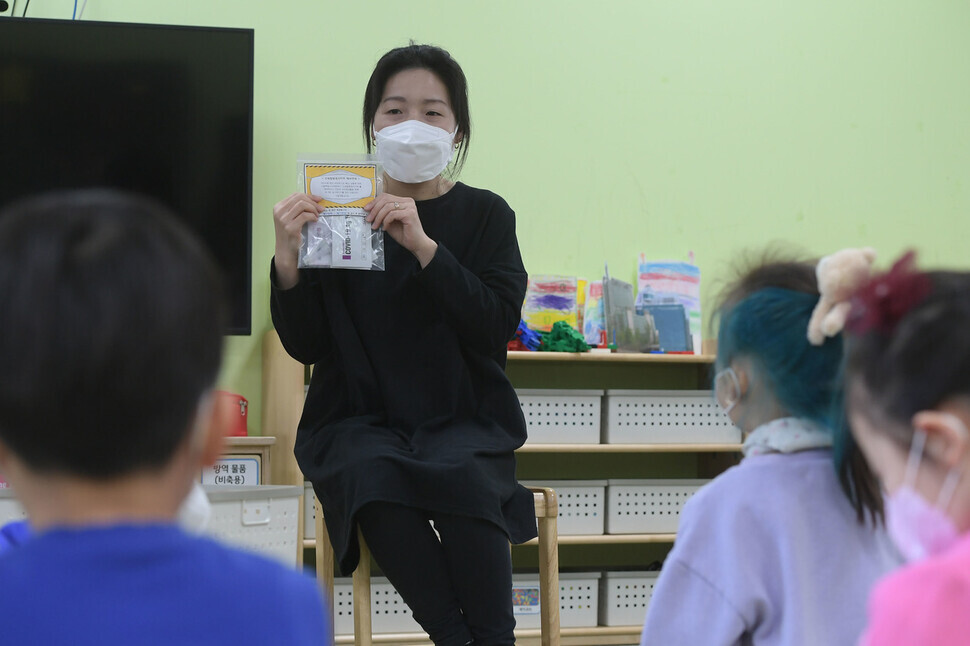 A teacher at a preschool in Seoul’s Guro District explains the COVID-19 test kit to her students on Tuesday. (pool photo)