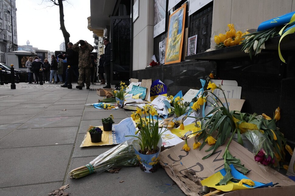 Signs and daffodils are seen scattered in front of the Ukrainian Embassy in Warsaw, Poland, on March 17. (Kim Hye-yun/The Hankyoreh)