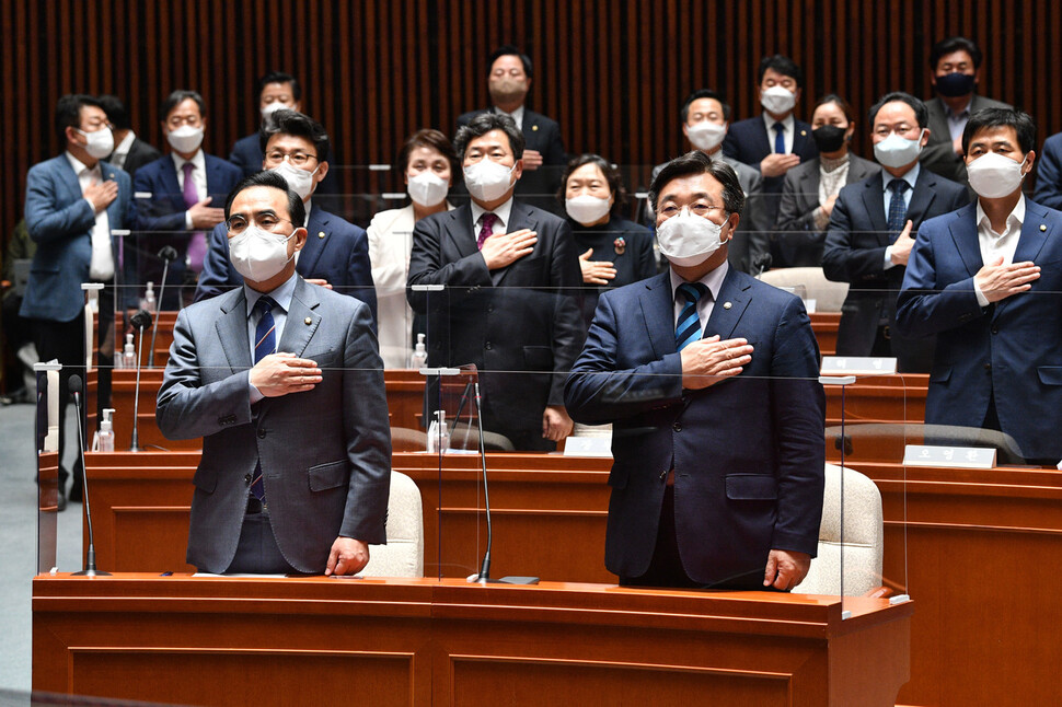 더불어민주당 윤호중 공동비대위원장과 박홍근 원내대표가 12일 오후 국회에서 열린 정책의원총회에서 국기에 경례하고 있다. 공동취재사진