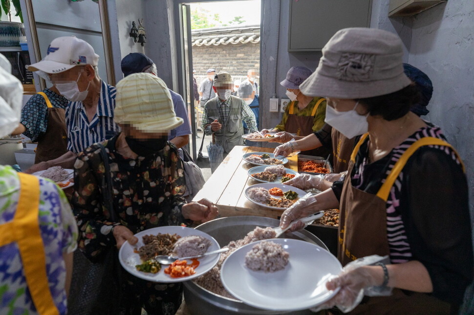 서울 종로구 원각사 무료급식소에서 노인들이 점심 식사를 하러 줄지어 들어서고 있다. 박승화 기자