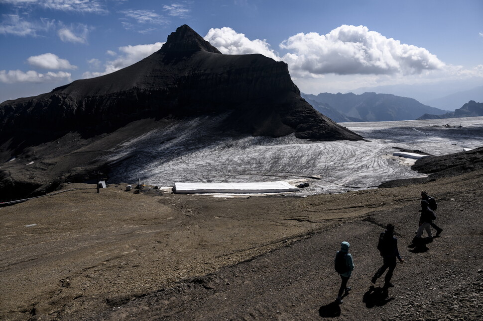 지난 28일 스위스 레디아블르레의 ‘빙하 3000’ 리조트에 등산객들이 걷고 있다. 빙하가 빠르게 녹는 걸 막기 위해 반사판 역할을 하는 흰색 담요를 덮어놨다. EPA 연합뉴스
