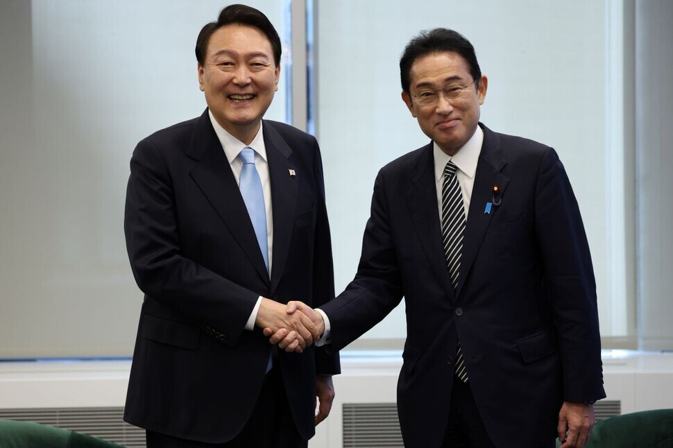 President Yoon Suk-yeol (left) shakes hands with Japanese Prime Minister Fumio Kishida during their informal summit in New York on Sept. 21. (Yonhap)