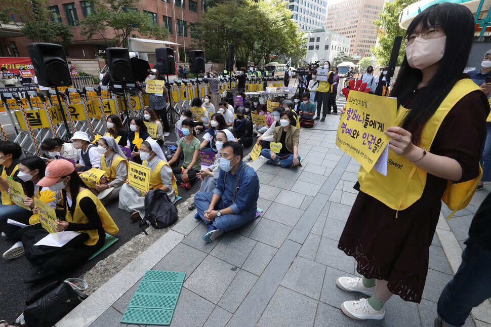 Participants in the 1,562nd Wednesday Demonstration in Seoul hold up signs during their demonstration on Sept. 21 outside the Japanese Embassy in Seoul.