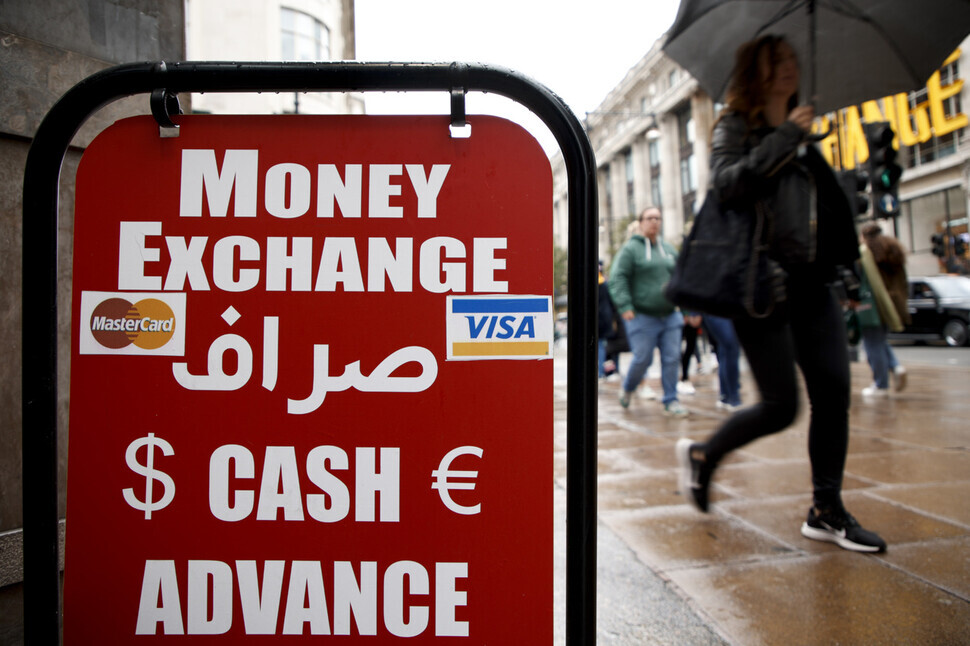 Londoners walk past a downtown money exchange on Sept. 26. (AP/Yonhap)