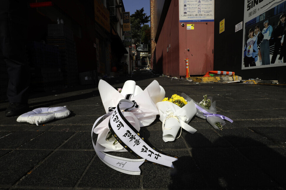 Bouquets sit on the ground in Itaewon on Oct. 30, one day after a tragic incident in which over 150 people were crushed to death in a crowd in the neighborhood during Halloween festivities. (Kim Myoung-jin/The Hankyoreh)