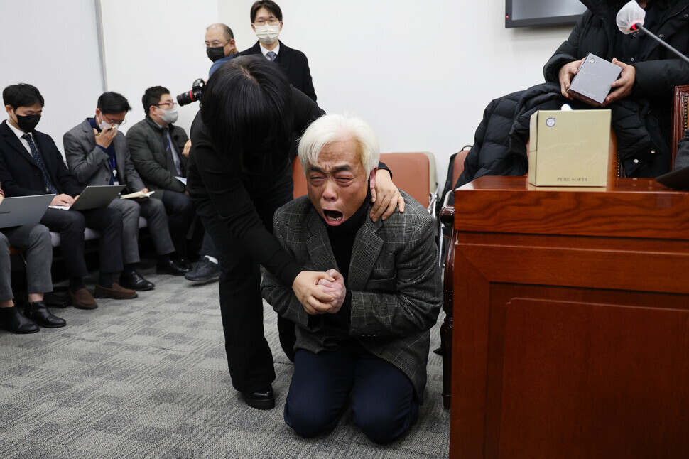 A family member of a person killed in the crowd crush that claimed over 150 lives in Itaewon in October falls to his knees during a National Assembly roundtable with victims’ families by a special committee for a parliamentary probe into the disaster on Dec. 1. (Yonhap)